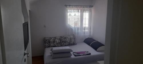 a couch sitting in a room with a window at Stan na dan -Bratunac- in Bratunac