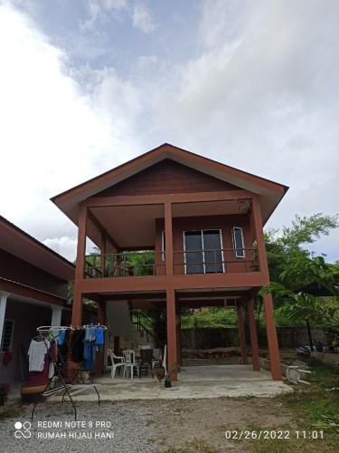 a large house with a balcony on top of it at Teratak Yoi in Pantai Cenang