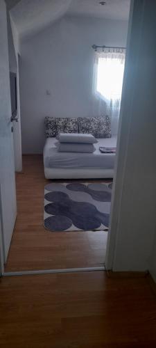 a bedroom with a bed and a rug on the floor at Stan na dan -Bratunac- in Bratunac