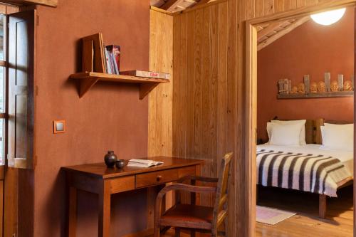 a bedroom with a bed and a desk with a desk sidx sidx sidx at Cerdeira - Home for Creativity in Lousã