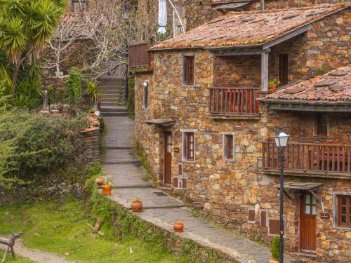 a stone house with a stairway leading up to it at Cerdeira - Home for Creativity in Lousã