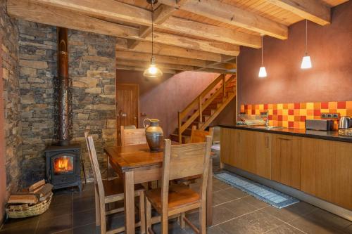 a kitchen with a table and a wood stove at Cerdeira - Home for Creativity in Lousã
