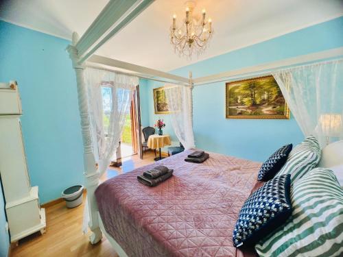 a bedroom with a bed with blue walls and a chandelier at Esmaraldas House of Love in Terrasini