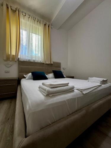 een slaapkamer met een groot wit bed en handdoeken bij Le Monde 2 in Borsh