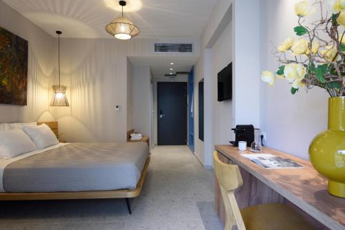a bedroom with a bed and a desk with a sink at Falena Luxury Rooms in Kalyves Poligirou