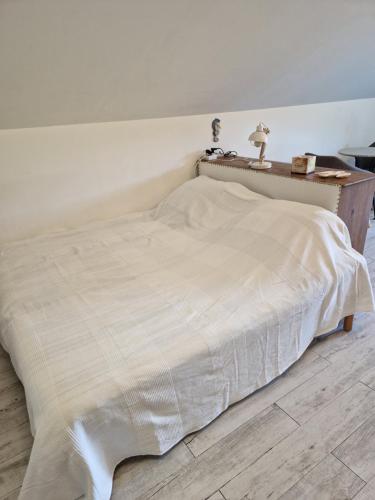 a bed with a white blanket on top of it at Chez Gabrielle in Gaillard