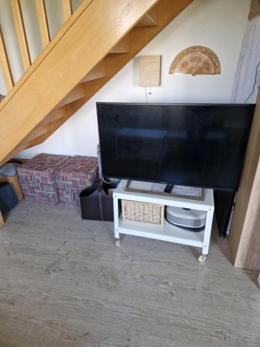 a large television on a white table in a room at Chez Gabrielle in Gaillard