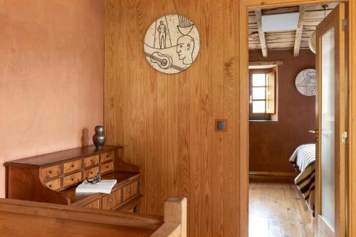 a room with a wooden wall with a clock on the wall at Cerdeira - Home for Creativity in Lousã