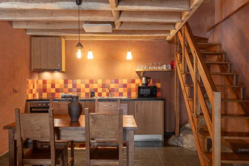 a kitchen with a wooden table and a wooden staircase at Cerdeira - Home for Creativity in Lousã