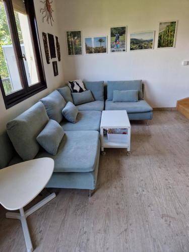 a living room with a blue couch and a table at Chez Gabrielle in Gaillard
