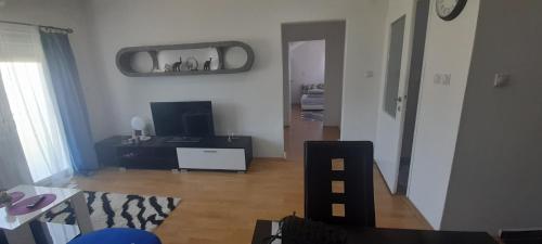 a living room with a table and a tv at Stan na dan -Bratunac- in Bratunac