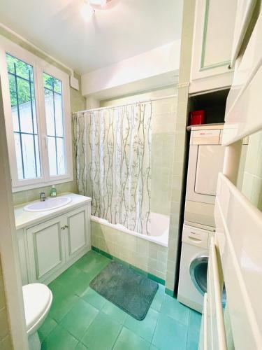 une salle de bain avec un lavabo, des toilettes et une douche dans l'établissement Ravière, à Paris