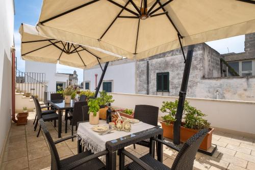 a patio with tables and chairs with umbrellas at Le due Torri in Avetrana