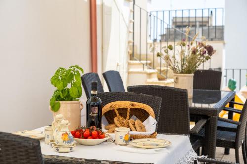 a table with a basket of food and a bottle of wine at Le due Torri in Avetrana