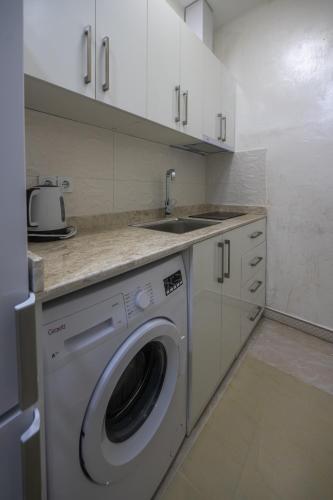 a kitchen with a washing machine and a sink at Gama Palace in Batumi