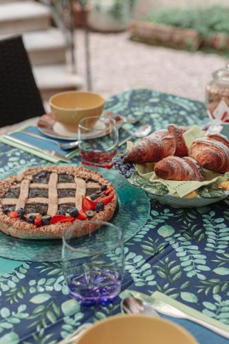 a table with two pies and croissants on it at B&B La Corte in Chioggia
