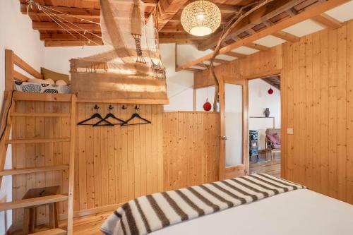 a bedroom with wooden walls and a bed in a room at Cerdeira - Home for Creativity in Lousã