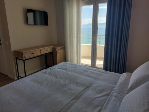 a bedroom with a bed and a view of the ocean at Hotel DEMOLI in Pogradec
