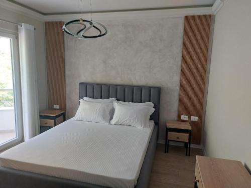 a bedroom with a bed with white sheets and pillows at Hotel DEMOLI in Pogradec