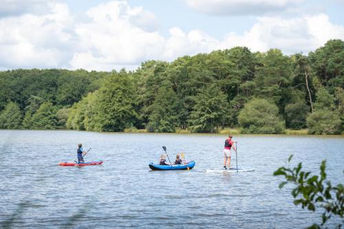 three people are kayaking on a lake at Huttopia Lac de Sillé in Sillé-le-Guillaume