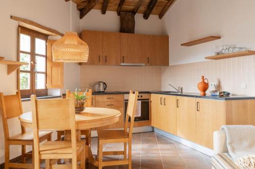 a kitchen with a wooden table and a table and chairs at Cerdeira - Home for Creativity in Lousã