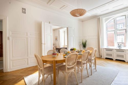 a dining room with a wooden table and chairs at Lovely 3BR Manor Flat 5 min from Tivoli Gardens in Copenhagen