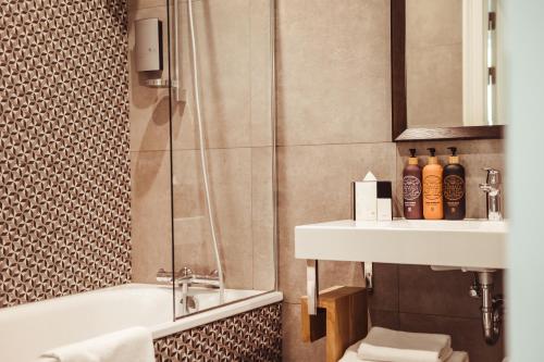 a bathroom with a shower toilet and a sink at Art Hotel Roma in Liepāja