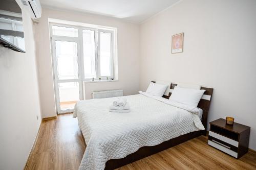 a white bedroom with a large bed with white sheets at Retreat relaxant cu 2 dormitoare! in Chişinău