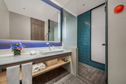 een badkamer met een wastafel en een spiegel bij Holiday Inn Express Shenzhen Futian Center, an IHG Hotel in Shenzhen