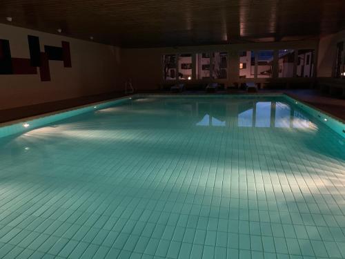 - une grande piscine dans un bâtiment éclairé dans l'établissement Ferienwohnung Allgäu, à Missen-Wilhams