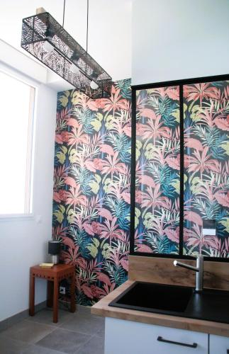 - une cuisine avec un mur recouvert de papier peint tropical dans l'établissement Le Freesia, à 20m de la plage, 5 min du centre-ville, à Roscoff