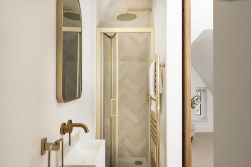 a bathroom with a shower with a sink and a mirror at 11 Tywarnhayle House, Perranporth in Perranporth