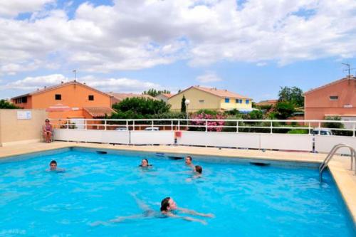 un groupe de personnes nageant dans une piscine dans l'établissement Villa de vacances 6 pers avec piscine proche plage - V0818, à Portiragnes