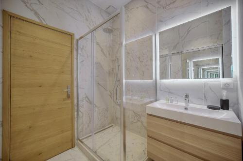 une salle de bain avec une douche, un lavabo et un miroir dans l'établissement Idéal 2 pièces rénové proche Palais 2P1, à Cannes