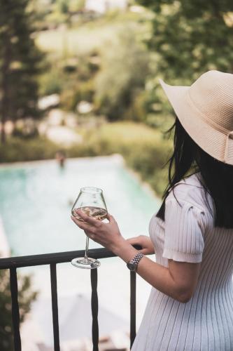 a woman in a hat holding a glass of wine at Les Lodges Sainte-Victoire Hotel & Spa in Aix-en-Provence