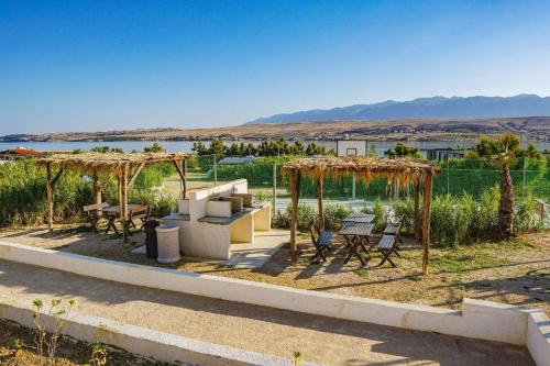 a patio with a grill and tables and umbrellas at Izzi Mobile Home - Terra Park SpiritoS in Kolan