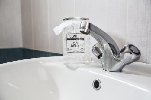 a bottle of water sitting on top of a sink at Pavlinia Hotel & Apartments in Ayia Napa