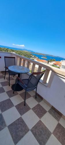 a table and chairs on a balcony with a view of the ocean at Apartments Villa Bella Vista Hvar in Hvar