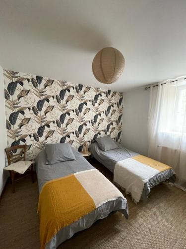 a bedroom with two beds and a wall at Maison côté halle " Le Parc" in Saint-Flour
