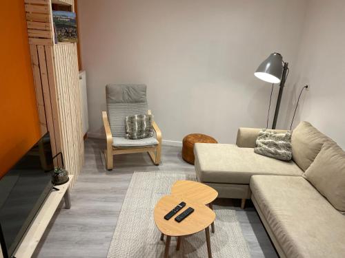 a living room with a couch and a chair at Maison côté halle " Le Parc" in Saint-Flour