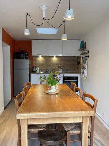 a dining room table with chairs and a kitchen at Maison côté halle " Le Parc" in Saint-Flour