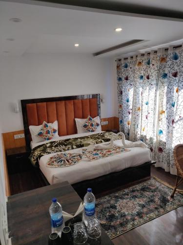 a bedroom with two beds and a table with water bottles at the mountain dreams in Kolur