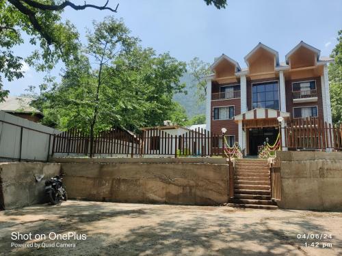 a house with a fence and stairs in front of it at the mountain dreams in Kolur
