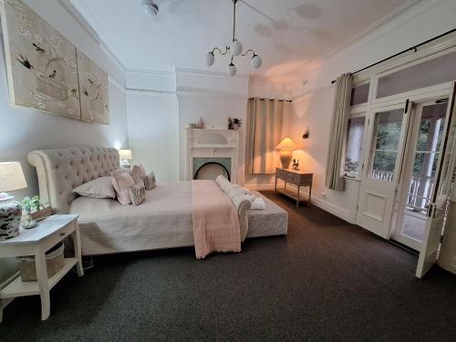 a bedroom with a large bed and a fireplace at The Bank On Kelly Hygge Villa, Scone in Scone