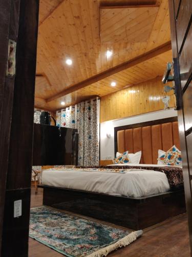 a bedroom with a large bed and a wooden ceiling at the mountain dreams in Kolur
