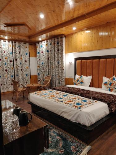 a bedroom with a large bed and a table at the mountain dreams in Kolur