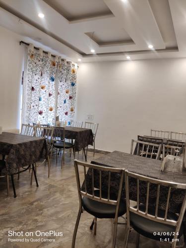 a room with tables and chairs and a curtain at the mountain dreams in Kolur
