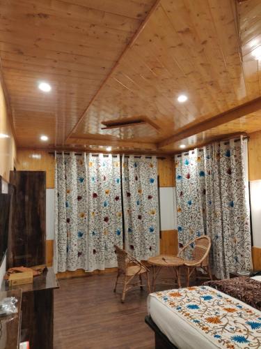 a bedroom with curtains and a bed and a table at the mountain dreams in Kolur