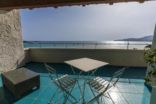 a table and chairs on a balcony with a view of the ocean at Villa Tre Mari in Villasimius