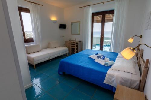 a bedroom with a blue bed and a living room at Villa Tre Mari in Villasimius